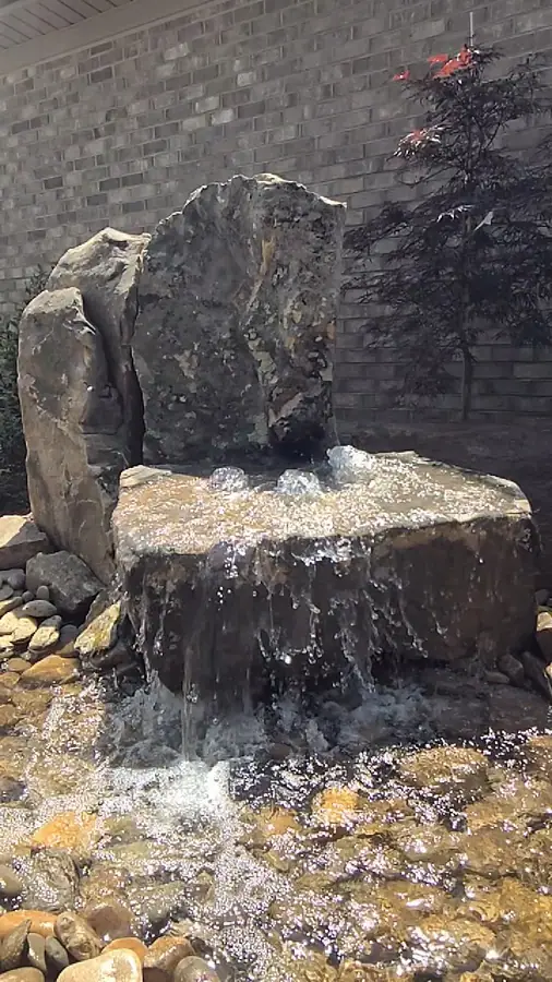 A stacked stone water feature built against an existing brick wall, turning dead space into the focal point. This Greer courtyard now has a centerpiece for relaxing.