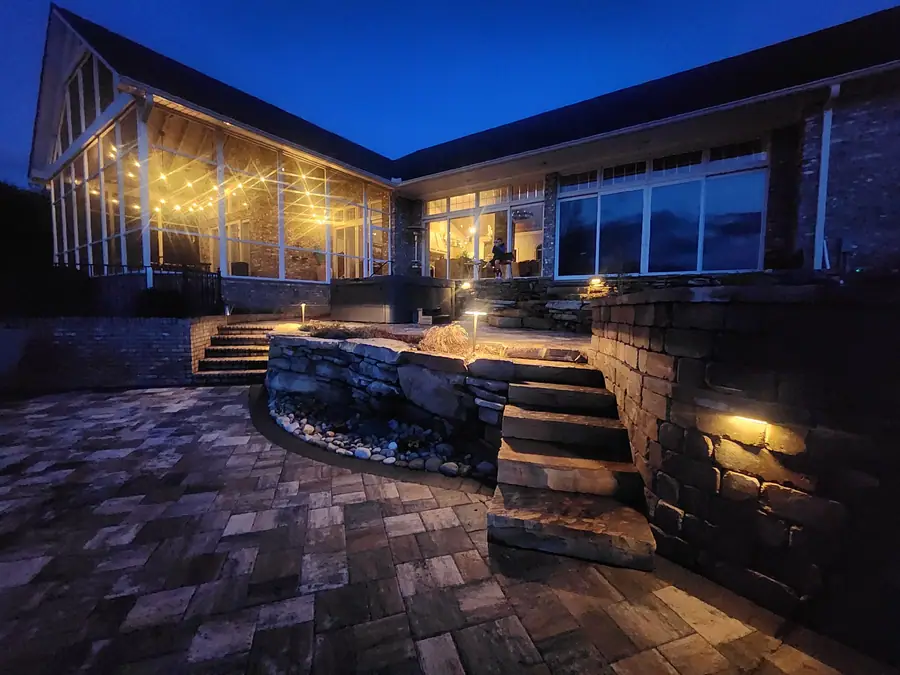 Paver terrace with a stacked stone fire pit and low-voltage lighting, built to be used after dark. This Campobello home has it all, with a view of the Blue Ridge and Glassy Mountain.