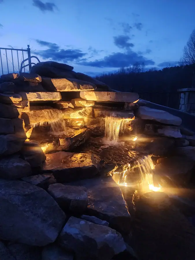 A stone waterfall with a built-in slide, part of this swimming pool restoration in Campobello.