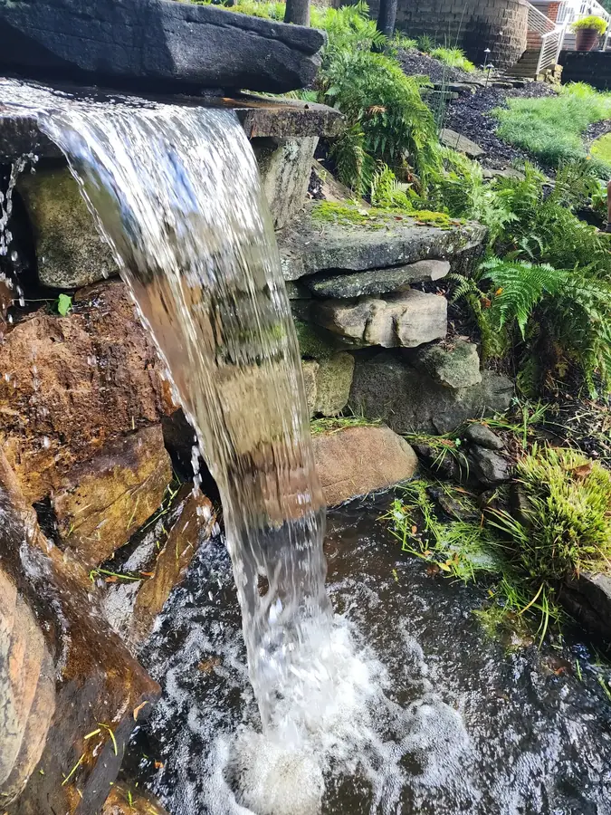 Moss-covered boulders set to control flow and sound — water does what you build it to do. This six-foot drop creates a breathtaking view every morning for this Upstate homeowner and a backyard getaway all its own.